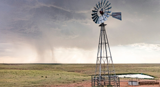 1. Molino de viento en funcionamiento bombeando agua en un campo en Pampa, Texas, USA – Seguro de auto barato en Pampa, Texas.