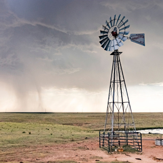 1. Molino de viento en funcionamiento bombeando agua en un campo en Pampa, Texas, USA – Seguro de auto barato en Pampa, Texas.