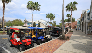 Coloridos carritos de golf estacionados en una calle principal del centro de Sumpter Landing. The Villages es una popular comunidad de jubilados amantes de los carritos de golf.